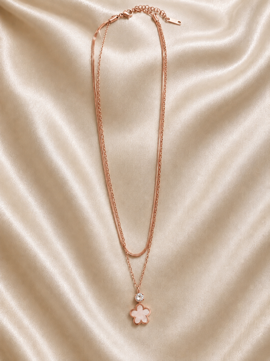 This layered necklace features a rose gold finish  flower pendant.