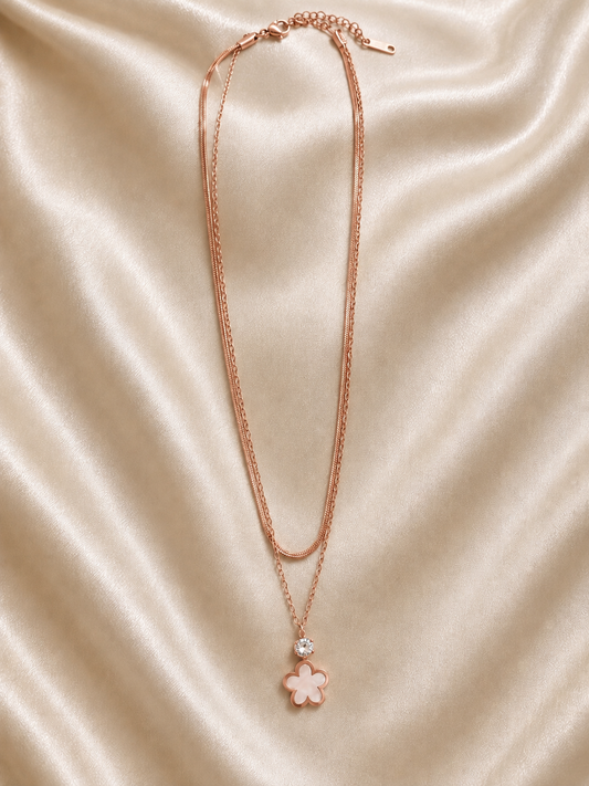 This layered necklace features a rose gold finish  flower pendant.
